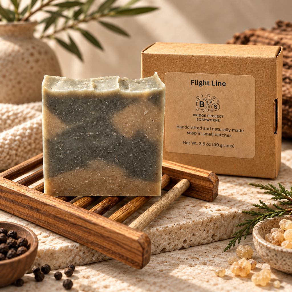 Flight Line artisan soap bar on a wooden soap dish beside its box